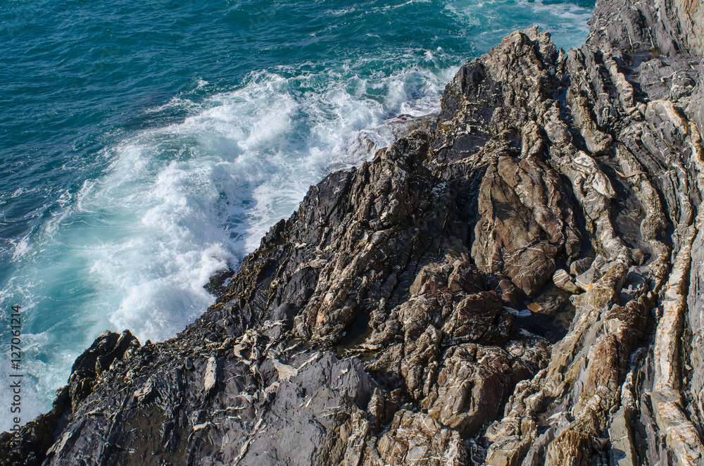 static rocky textures and dynamic sea water meet at the mediterranean coastline of Nervi in Genoa, Italy