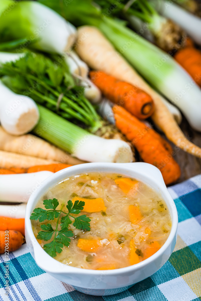 Vegetable soup in a bowl and fresh vegetables on wooden table Vegetable soup in a bowl and fresh vegetables on wooden table