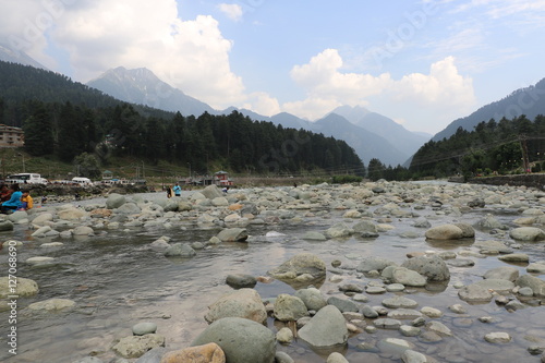 Beautiful scenic Lidder river flowing through Pahalgam Valley in Jammu & Kashmir. People enjoying here around the world.