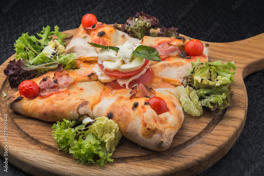 italian pizza calzone with tomato, salad and mozzarella italian pizza calzone with tomato, salad and mozzarella
