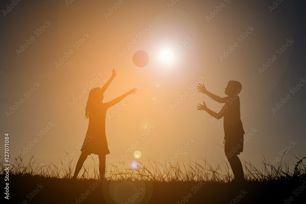 Silhouette children playing football on the sky sunset. Time on holiday