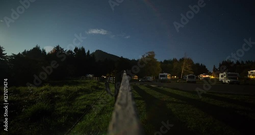 Tongue Point, Washington, USA - starry night with moonlight and moving shadows on the campground with illuminated camper vans - Timelapse without motion photo