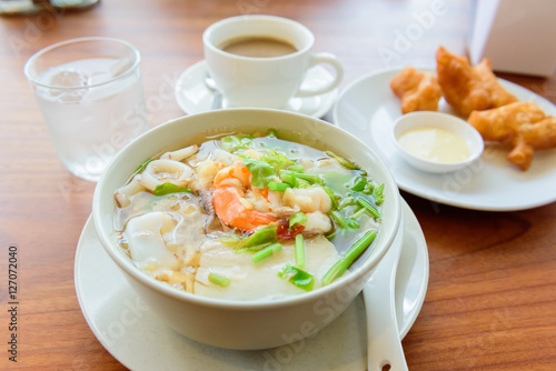 Bowl of Shrimp Porridge and patongko on wooden background