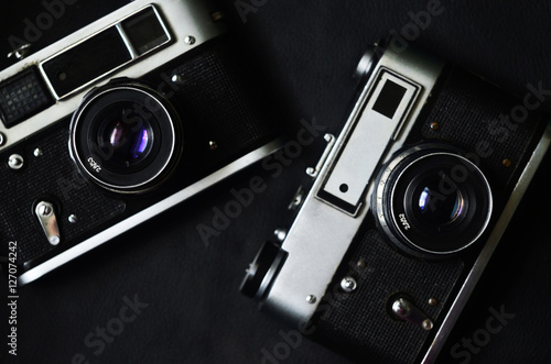 An old photo cameras from mid of 20th century on black leather background photo