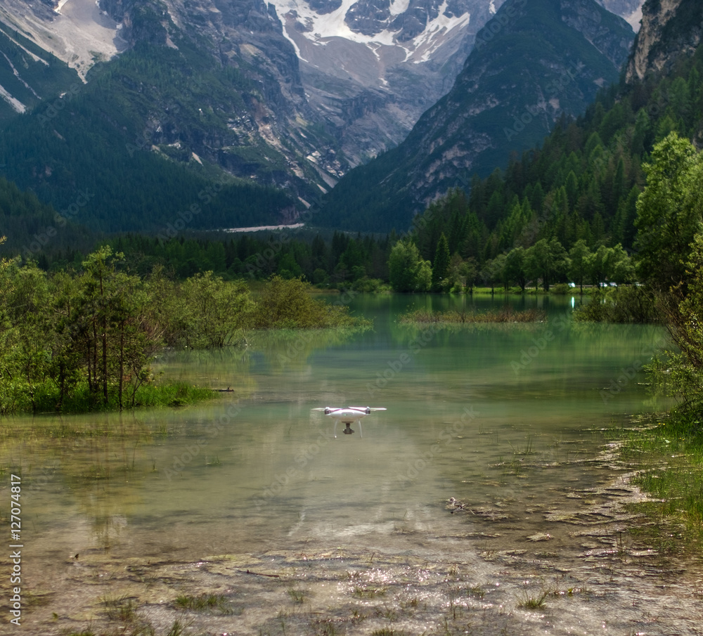 Drone flying over mountain lake. Alps, Italy.