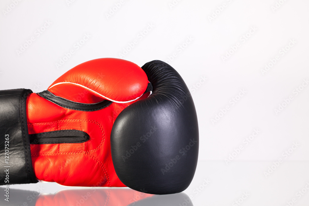 Red and black boxing gloves on a glass table