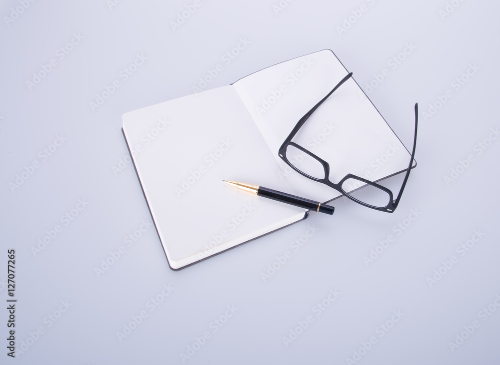 notebook with glasses and pen on the blackground. notebook with glasses and pen on the blackground.