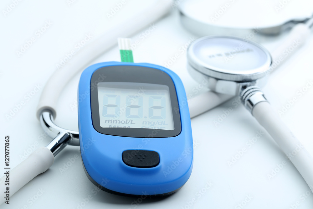 Blood glucose meter and stethoscope on white background Blood glucose meter and stethoscope on white background