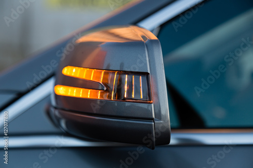 Rear view mirror with yellow lamp light on of the luxury car of famous german vendor photo