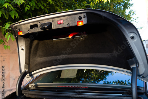 Open the tailgate of a luxury sedan car with the control buttons and signal lights photo