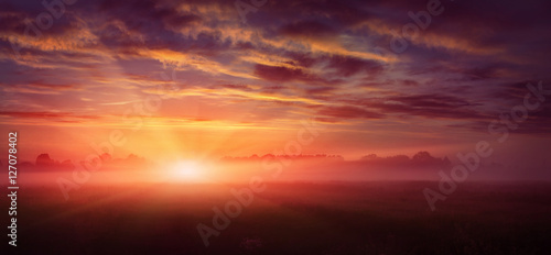 fantastic landscape. majestic misty morning over meadow. colorful sky with overcast clouds, under the influence of sunlight. dramatic picturesque scene. beauty of the world. creative images