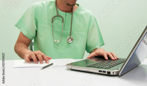 Doctor working with computer notebook at desk
