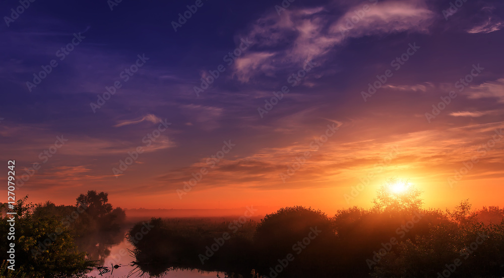wonderful dramatic scene. fantastic foggy sunrise over the meadow with colorful clouds on the sky. picturesque rural landscape, misty morning. color in nature. beauty in the world wonderful dramatic scene. fantastic foggy sunrise over the meadow with colorful clouds on the sky. picturesque rural landscape, misty morning. color in nature. beauty in the world