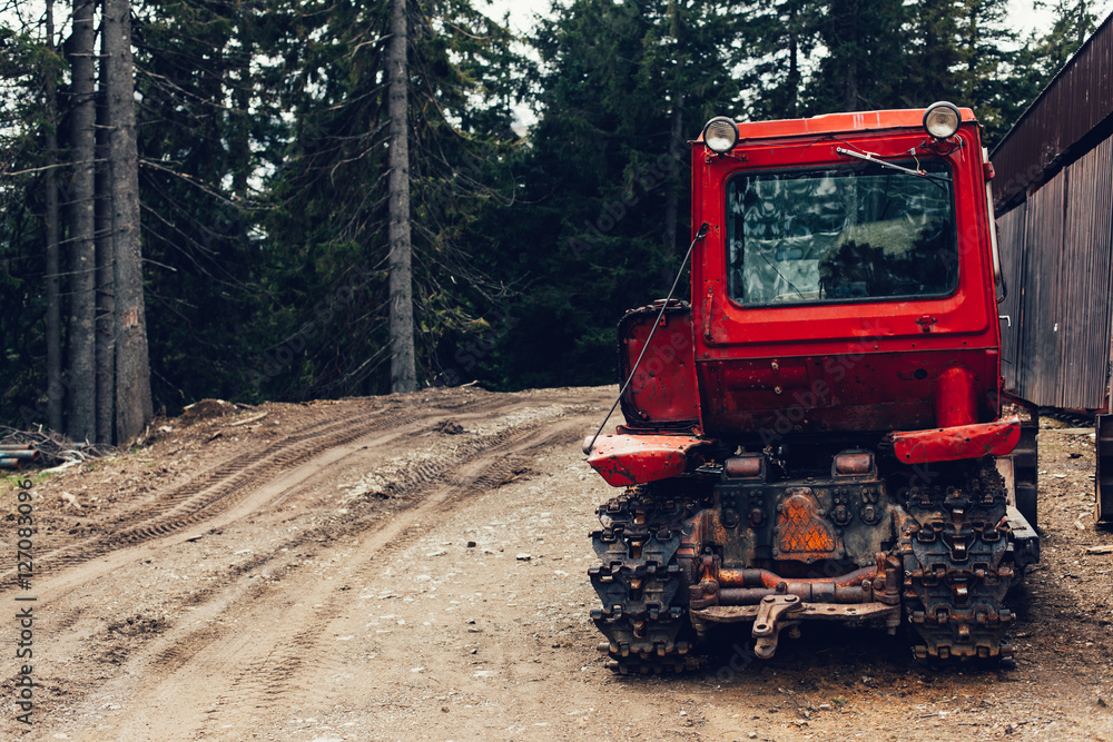 tractor bonnet and big wheels on natural soil road in spring forest tractor bonnet and big wheels on natural soil road in spring forest