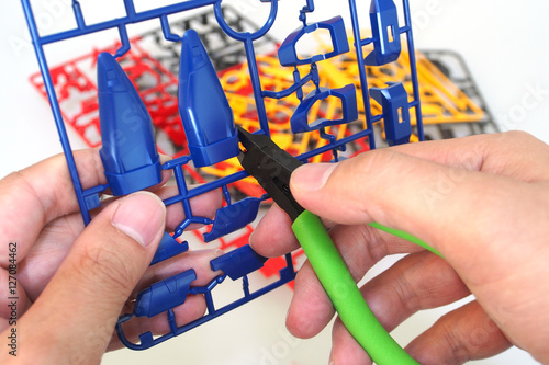 Man use nipper cutting a part of plastic model kit isolated on w