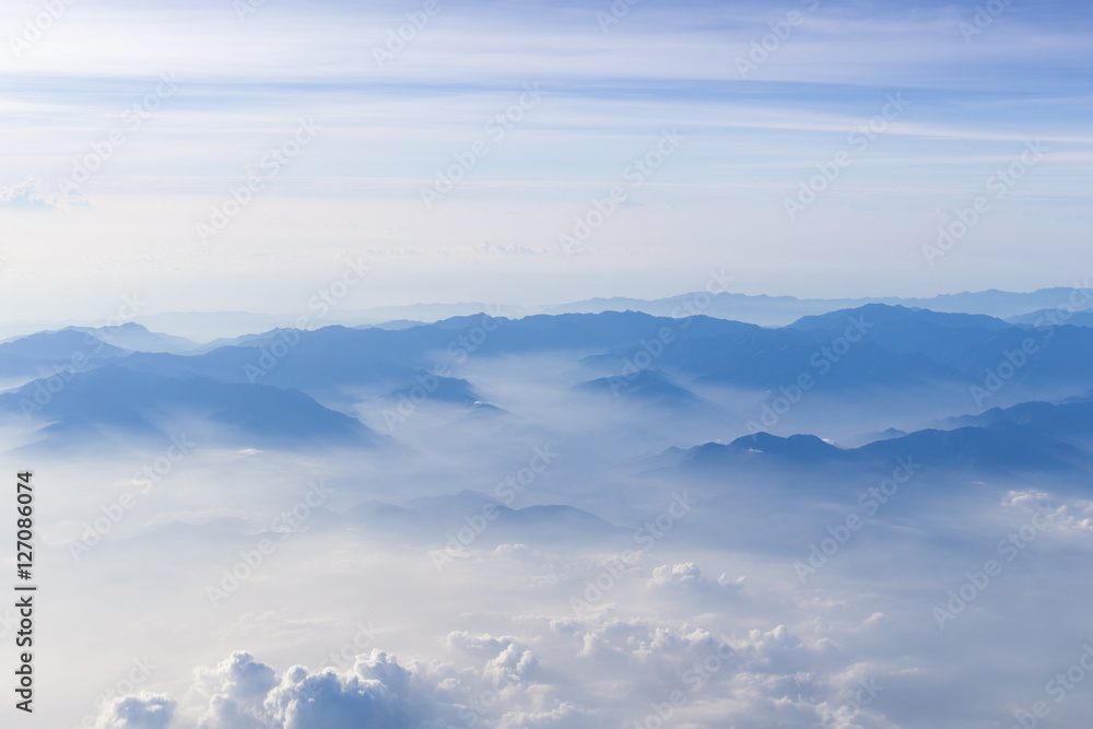 Fototapeta premium Blue sky and mountains view from airplane stylized hipster background with copyspace