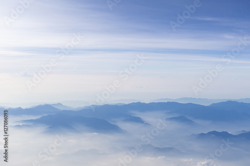 Blue sky and mountains view from airplane stylized hipster background with copyspace