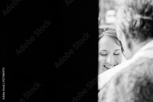 Black and white side photo of bride and priest. Wedding ceremony