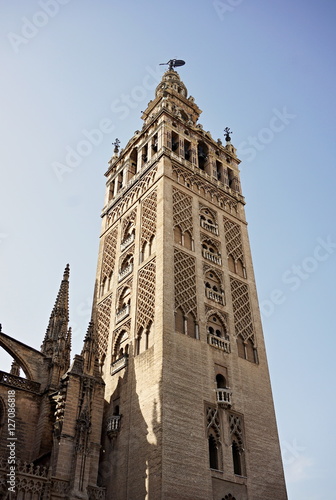 Giralda, famous bell tower of the Seville Cathedral in Spanish city of Sevilla, built as a minaret and rebuilt as a tower of famous church as a symbol of Arab and Moorish architectural period in Spain photo