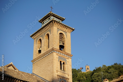 Fototapeta Naklejka Na Ścianę i Meble -  Top of the church in Granada in southern Spain as a typical Spanish bell tower, symbol of Spanish religious architecture and design 