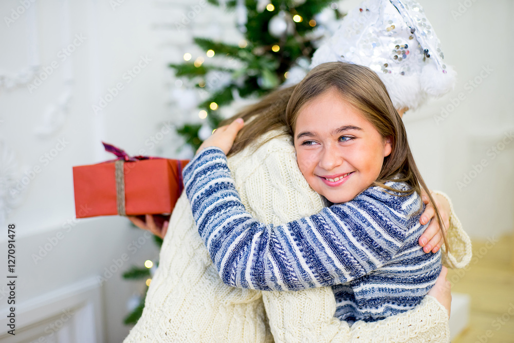 Two girl, gift, Christmas tree, white hats Two girl, gift, Christmas tree, white hats