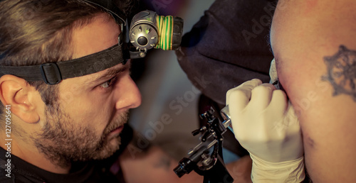 Artist making tattoo on male customer