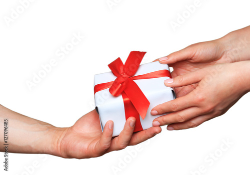 Male and female hands with white gift box with bow over white