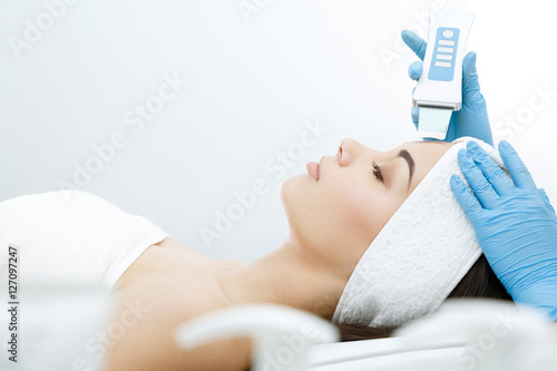 Doctor doing procedure of ultrasonic cleaning of face
