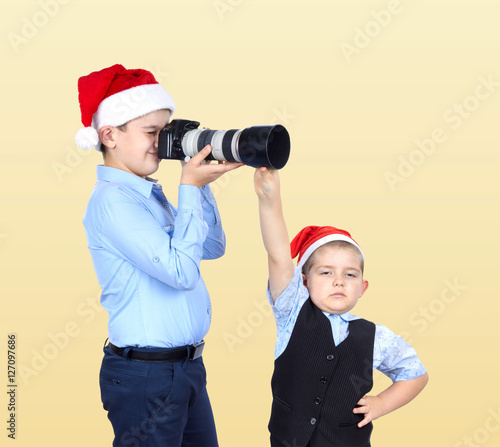 In caps of Santa Claus the brothers are photographing © andreyfire