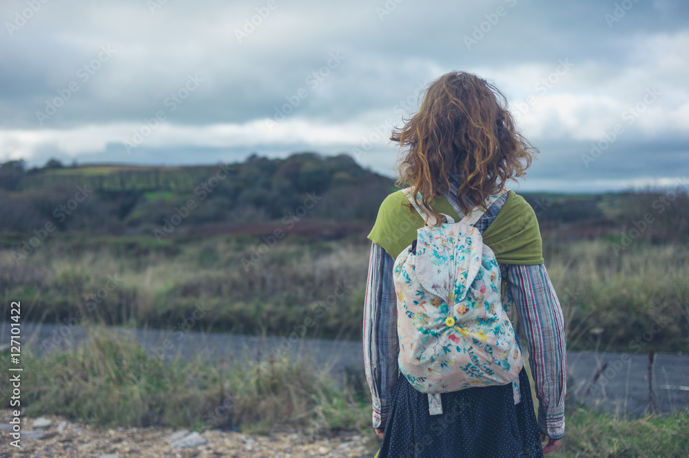 © LoloStock - Woman standing by road in countryside