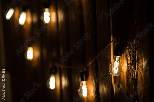 Vintage incandescent Edison type bulbs on wooden wall