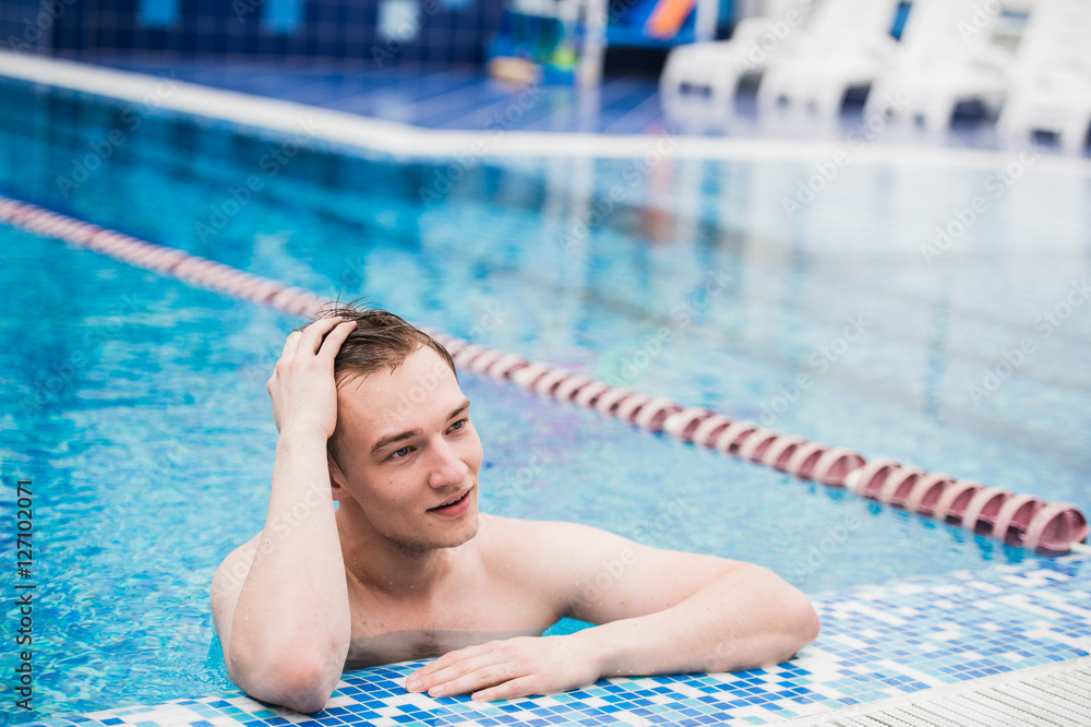 Portrait of young sexy handsome man in swimming pool