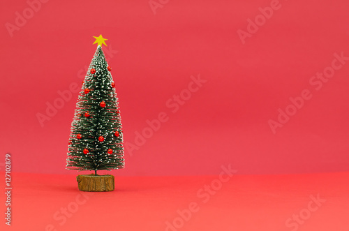 Decorated Christmas tree isolated on red background