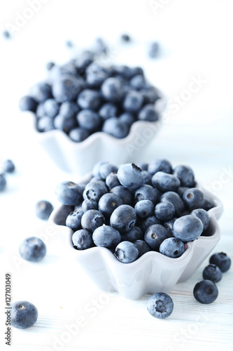 Ripe and tasty blueberries on blue wooden table