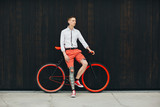 Hipster with bycicle and tatoo at dark background