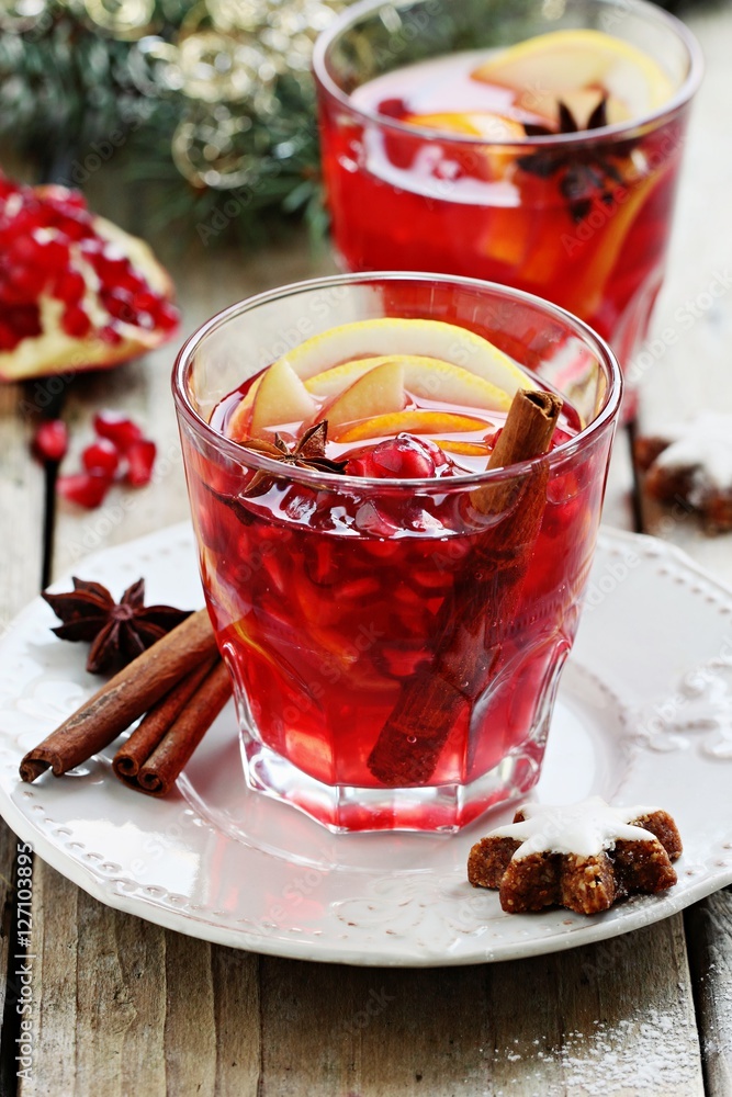 Winter sangria oder mulled wine :traditional drinks with spicy,citrus fruits and pomegranate . Rustic style.Selective focus Winter sangria oder mulled wine :traditional drinks with spicy,citrus fruits and pomegranate . Rustic style.Selective focus