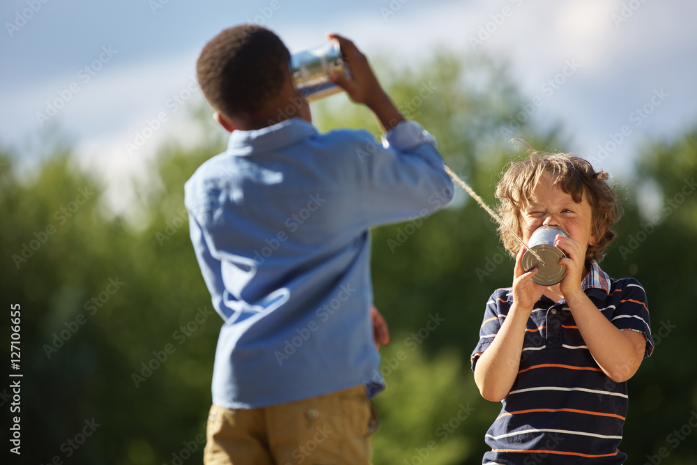 Obraz premium Two boys playing tin can telephone