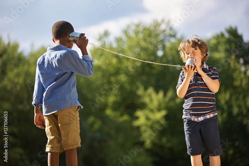 Two boys play tin can telephone photo