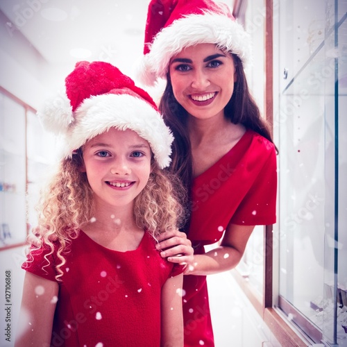 Composite image of portrait of mother and daughter in christmas 