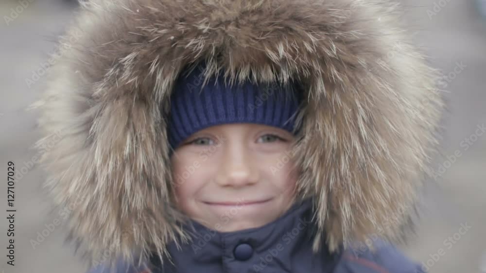 Portrait of a boy in winter jacket with hood on his head Portrait of a boy in winter jacket with hood on his head