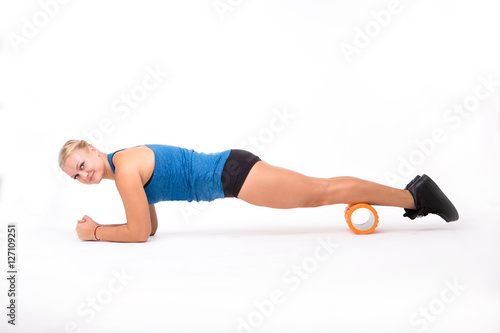 Happy sports and fitness woman doing push ups while training isolated on white background. Beautiful lady looking at camera while practicing.
