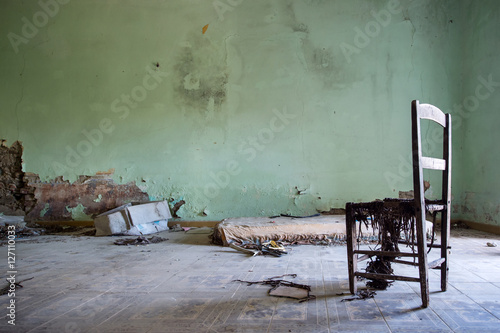 room in the house destroyed with only a chair and mattress