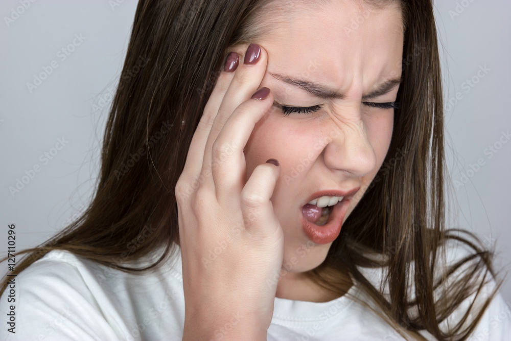 pretty womanover gray background stress and headache having migraine pain she screaming closeup pretty womanover gray background stress and headache having migraine pain she screaming closeup