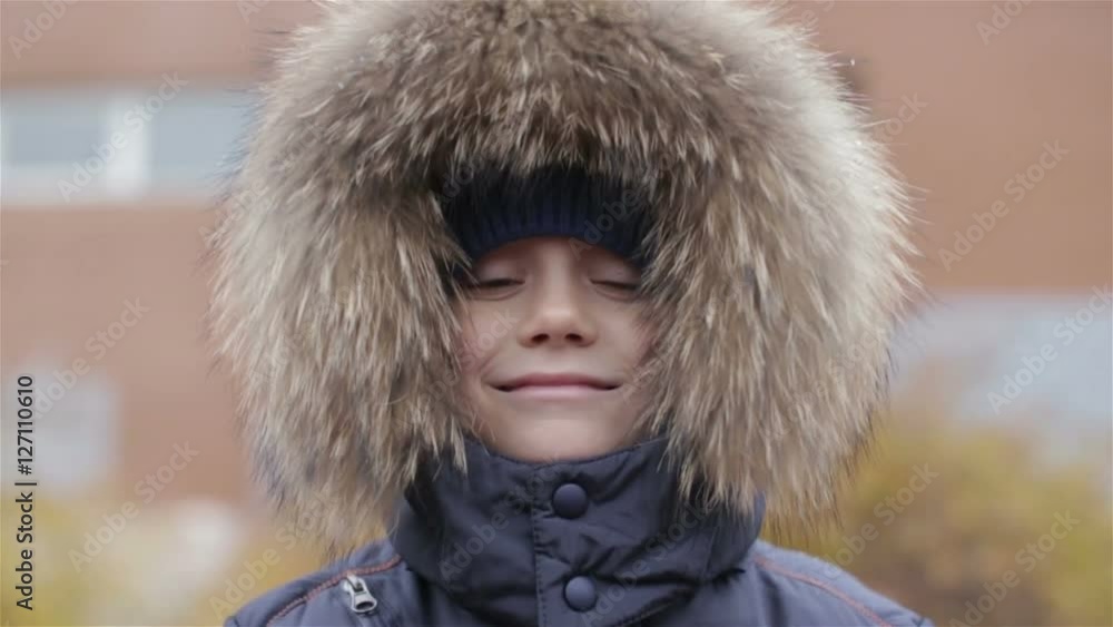 Portrait of a boy in winter jacket with hood on his head Portrait of a boy in winter jacket with hood on his head
