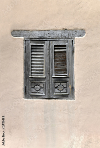Closed window shutters on old stone wall