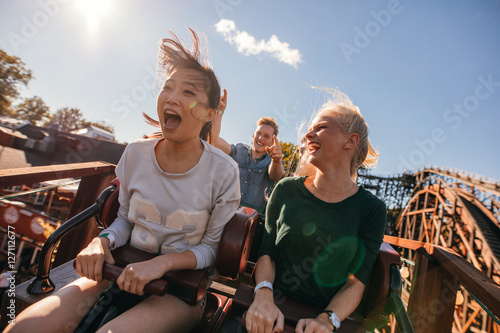 Young friends on thrilling roller coaster ride photo