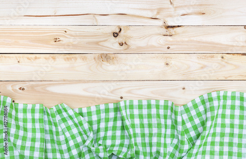 Green tablecloth on wooden table, top view