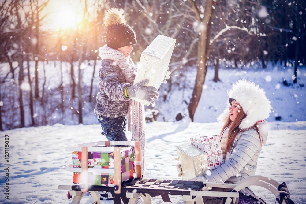 Composite image of brother and sister holding presents