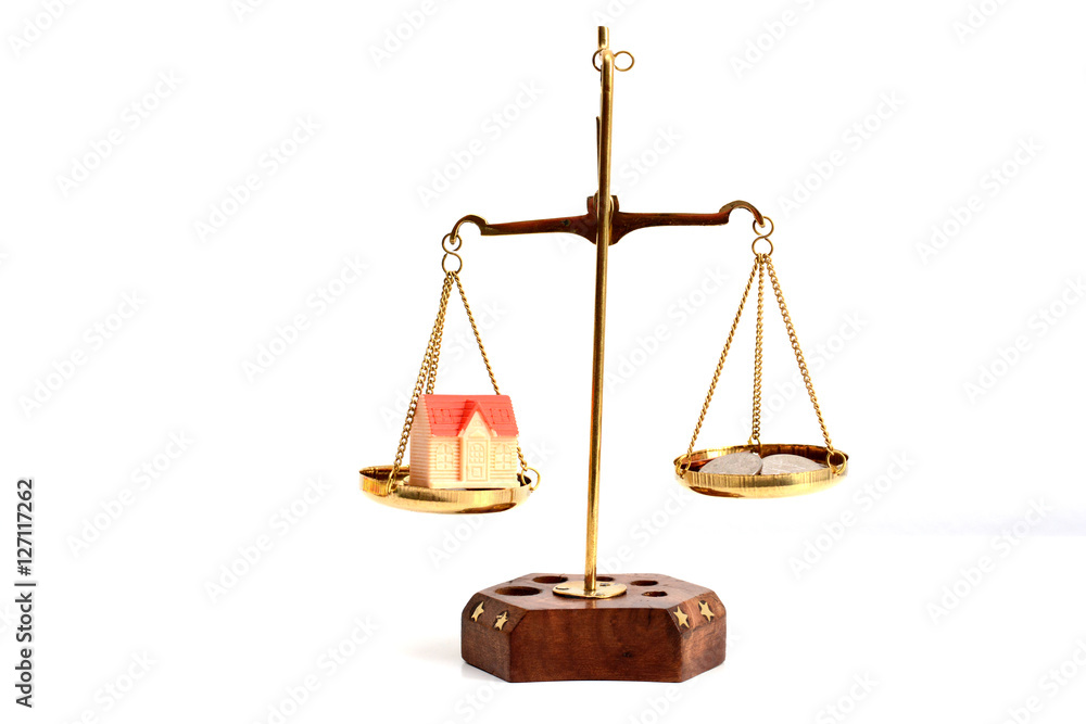 Small model house and cash money in balance – real estate concept Small model house and cash money in balance – real estate concept