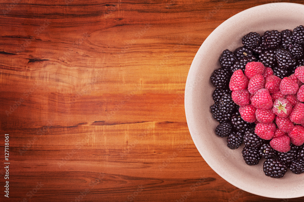 Ceramic plate with heart shaped berries on the right of the wooden table with clipping path. Top view. Ceramic plate with heart shaped berries on the right of the wooden table with clipping path. Top view.